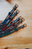 Set of colorful dog collars on a wooden surface