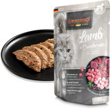 Leonardo cat food packaging with lamb and cranberries package with cat treats on a black plate