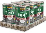 Six cans of Belcando Baseline Turkey wet cat food arranged in a wooden tray with 'MADE IN GERMANY' printed on the front, on a clean white background.